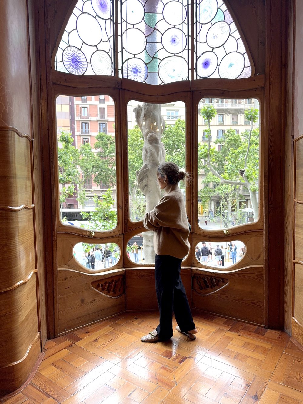 Melissa Rojas looking out of a stained-glass window